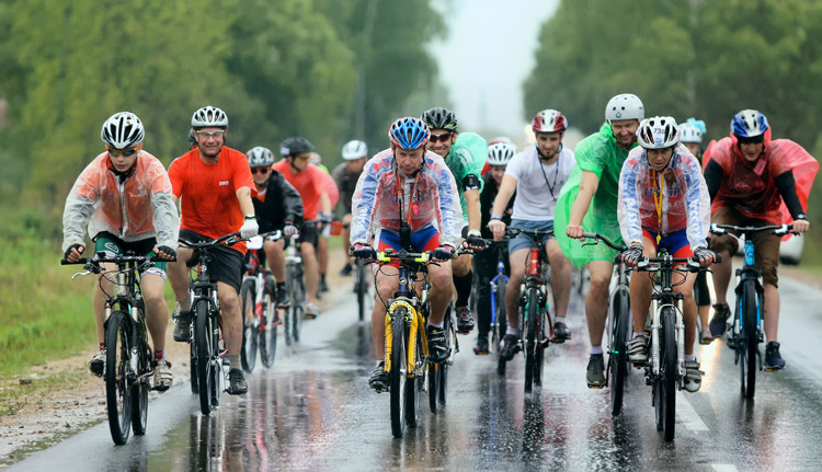 a group of cyclists riding electric bikes in the rain
