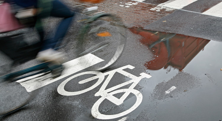 puddle of water on the road with an ebike riding over it