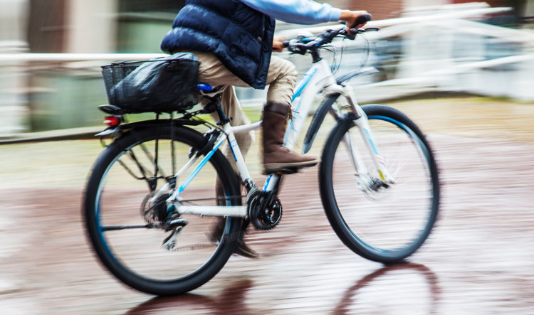 man riding ebike on wet road