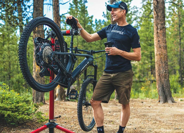 man performing electric bike maintenance in the woods
