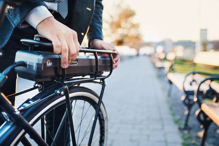 man adjusting electric bike battery