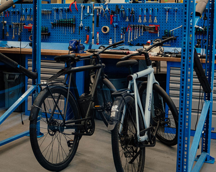 two electric bikes parked in a repair shop