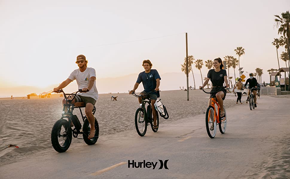 people riding three hurley electric bikes by the beach