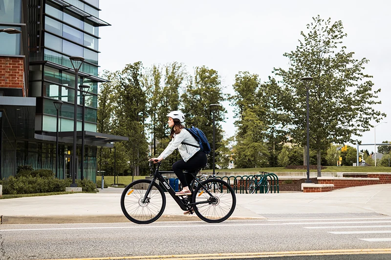 woman riding a black commuter electric bike