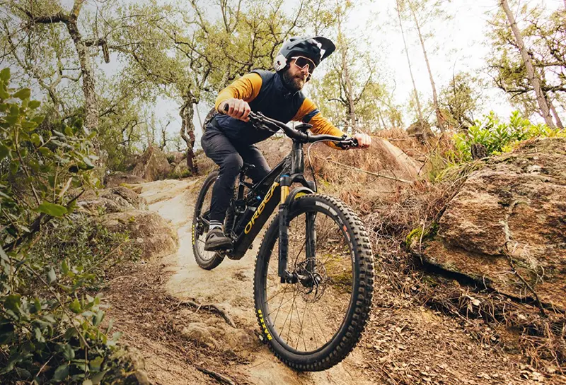 cyclist descending a hill with an orbea rise e-mtb